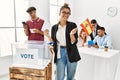 Young spanish voter woman smiling happy holding spain flag at vote center