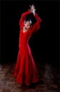 Young Spanish woman dancing flamenco in traditional red dress