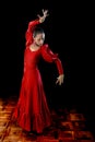 Young Spanish woman dancing flamenco in typical folk red dress