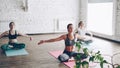 Young spiritual girls are doing relaxation breating exercises in yoga studio. Relaxing self-development energy concept.