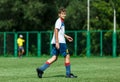 Young sport boys in white sportswear running and kicking a ball on pitch. Soccer youth team plays football in summer. Royalty Free Stock Photo