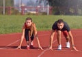 Young sport couple in starting position prepared to compete and run