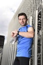 Young sport man checking time on chrono timer runners watch holding water bottle after training session Royalty Free Stock Photo