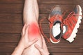 Young sport man with strong athletic legs holding knee with his hands in pain after suffering ligament injury during a running Royalty Free Stock Photo