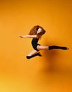 Young sport woman gymnastics doing jumping fitness exercise at sport gym jump on yellow Royalty Free Stock Photo