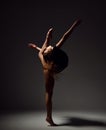 Young sport woman gymnastics doing stretching fitness exercise at dark gym Royalty Free Stock Photo