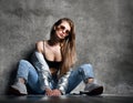 Young sport woman after workout exercise sitting under snow in silver thin down puffer jacket blue jeans Royalty Free Stock Photo