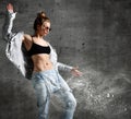 Woman workout exercise stand in silver down puffer jacket blue jeans sunglasses on loft wall with dust snow splashes Royalty Free Stock Photo