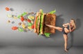 Young sport women boxing a hamburger as unhealthy food