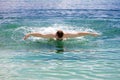 Young sporting man swims in the sea dolphin style. Royalty Free Stock Photo