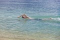 Young sporting man swims in the sea