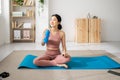 Young sportive asian woman holding bottle of water after work out at home Royalty Free Stock Photo