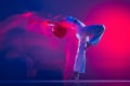 Young sportive beautiful girl, hip-hop dancer dancing hip hop isolated on purple background in pink neon light. Youth Royalty Free Stock Photo