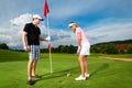 Young sportive couple playing golf on a course Royalty Free Stock Photo