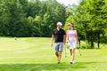 Young sportive couple playing golf on a course Royalty Free Stock Photo