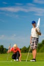 Young sportive couple playing golf on a course Royalty Free Stock Photo