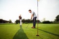 Young sportive couple playing golf on a golf course - Image Royalty Free Stock Photo