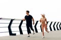 Young sportive couple in sportswear running sprint on the bridge on the coast, Fit Runner fitness runner during outdoor workout at Royalty Free Stock Photo