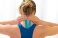 Young sportive female athlete touching her injured neck after treatment with kinesio tape. Rear view close up. Kinesiology. Royalty Free Stock Photo