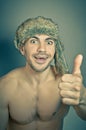 Young sportive handsome man in stylish hipster fur hat with crazy emotions agree and smile, shows the gesture OK