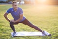 Young sportive man doing stretching exercises before running in morning field outdoors Royalty Free Stock Photo