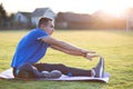 Young sportive man doing stretching exercises before running in morning field outdoors Royalty Free Stock Photo