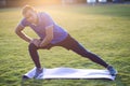 Young sportive man doing stretching exercises before running in morning field outdoors Royalty Free Stock Photo