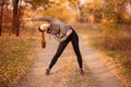 Young sportive woman doing exercises in autumn. Sportswoman stretching her body. Royalty Free Stock Photo