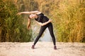 Young sportive woman doing exercises in autumn. Sportswoman stretching her body. Royalty Free Stock Photo