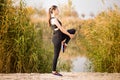 Young sportive woman doing exercises in autumn. Sportswoman stretching her body. Royalty Free Stock Photo