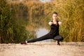 Young sportive woman doing exercises in autumn. Sportswoman stretching her body Royalty Free Stock Photo