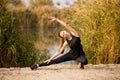 Young sportive woman doing exercises in autumn. Sportswoman stretching her body Royalty Free Stock Photo