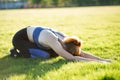 Young sportive woman doing fitness exercises on green grass in warm summer day outdoors Royalty Free Stock Photo