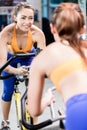 Young sportive woman pedaling during indoor gym cycling