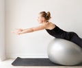 Young sportive woman sitting on the fitness ball warming out before workout Royalty Free Stock Photo