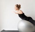 Young sportive woman sitting on the fitness ball warming out before workout Royalty Free Stock Photo