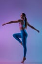 Young sportive woman training isolated on gradient studio background in neon light. athletic and graceful