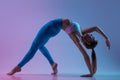 Young sportive woman training isolated on gradient studio background in neon light. athletic and graceful