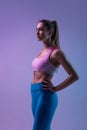 Young sportive woman training isolated on gradient studio background in neon light. athletic and graceful