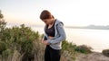 Young sports girl putting on after exercise by the sea over huge cliffs at sunset. She wears tights and sports bra Royalty Free Stock Photo