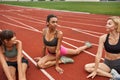 Young sports girls stretch on stadium treadmill