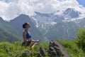 Young sports woman doing yoga on the green grass in the summer.