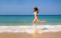 Young sports woman in white bikini jumping on the beach. Royalty Free Stock Photo