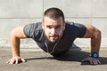 Young sportsman doing push ups and listening to music with headphones. Sport, fitness, street workout concept, close up