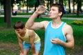 Young sportsman drinking water at the park