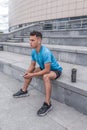 Young sportsman, male athlete, listens music with headphones, summer city, workout with fitness training, active Royalty Free Stock Photo