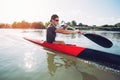 Sportsman in the Red Kayak Paddling on the River. Royalty Free Stock Photo