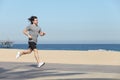 Young sportsman running on the seafront of the beach