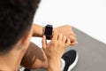 Young sportsman uses fitness tracker closeup over white studio background