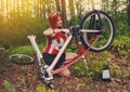 Young sportswoman bicyclist repairing her mtb bike in the forest Royalty Free Stock Photo